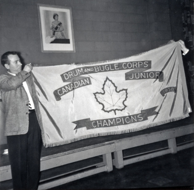 Eric Burton, guard instructor, with our first Championship flag (1958)
Submitted by Phil Hennings
Keywords: 1958