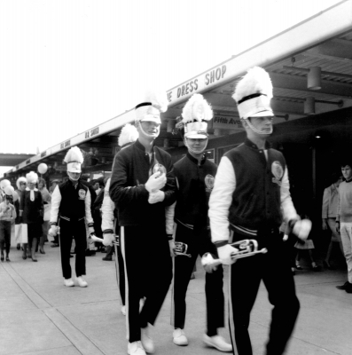 At the opening of a women's fashion store (1965)
This was not an "official" corps performance so we wore our jackets rather than our blouses. We supplied music and acted as a backdrop as models showed off the lastest fashions the store was selling.
R-L: Keith Buckingham, Doug Mackenzie, Clayton Keat, (someone's right arm), Ed Collins
Photo submitted by Bob Carell
Keywords: 1965