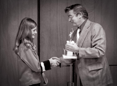 Pat Tunney (now Buttigieg) receives an award from Vic DeCloux (Optimists Cadets Awards dinner, 1975)
Photo by Don Daber
Keywords: 1975