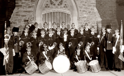 Opti-Corps in front of a church with two instructors from 2nd Signals (Ross Wilson on the left and Bill Self on the right) (Islington United Church, 1956)
the guy in the middle with glasses and white gloves is Roy Lawrence, the drum major

Submitted by Phil Hennings
Keywords: 1956